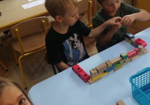 Dzieci manipulują drewnianymi klockami